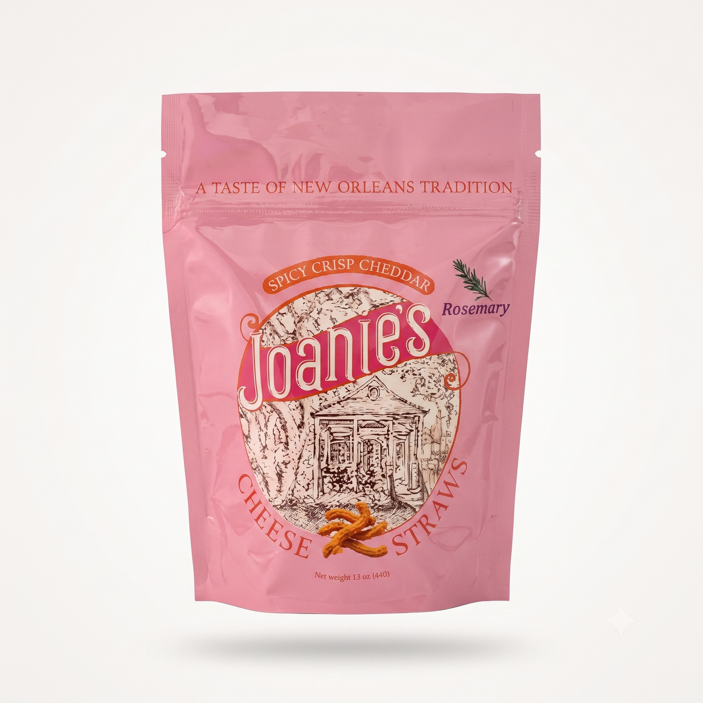 A pink stand-up pouch of Joanie's Spicy Crisp Cheddar Cheese Straws on a clean white background. The packaging features a prominent circular logo with the brand name 'Joanie's' in white script, an illustration of a New Orleans street scene, and small images of cheese sticks and rosemary.